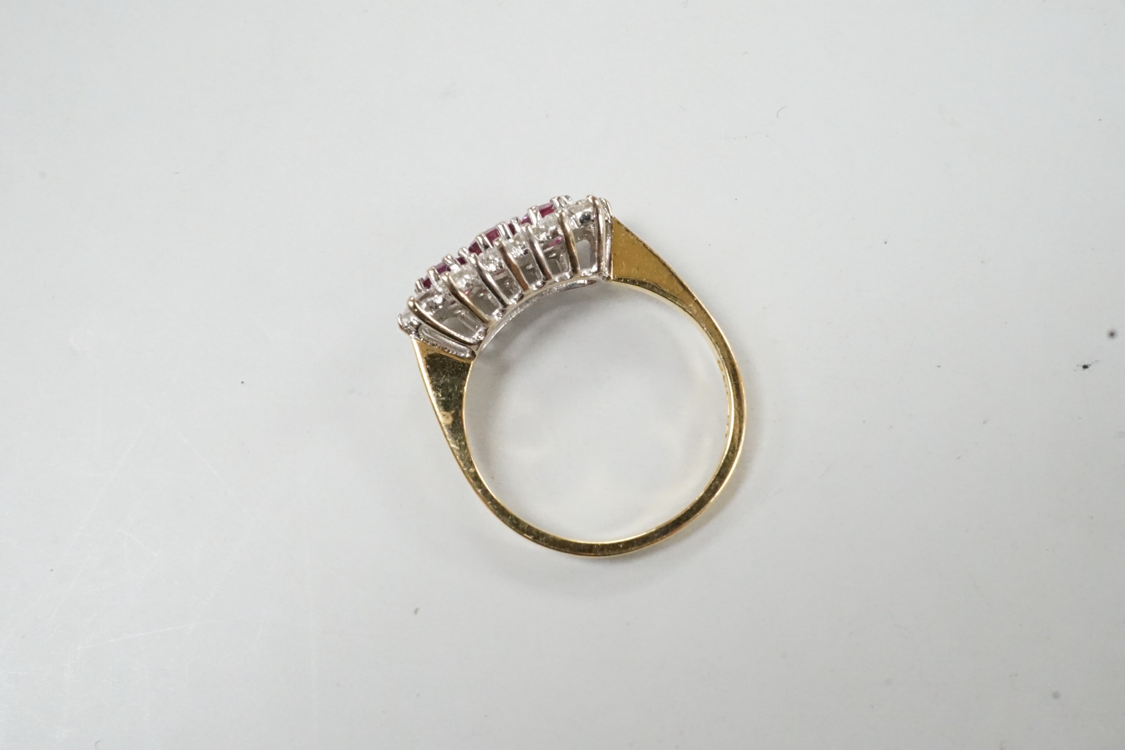 A modern 18ct gold, ruby and diamond set triple cluster ring, size L, gross weight 3.3 grams.